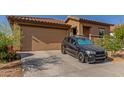 View of home exterior showcasing garage and a black car parked on driveway at 4050 W Coles Rd, Laveen, AZ 85339