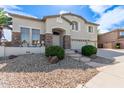 Charming two-story home featuring a three car garage, stone accents, and lovely landscaping at 4490 S Rio Dr, Chandler, AZ 85249