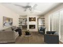 Cozy living room featuring a fireplace, built-in shelving, and plantation shutters for natural light at 6313 E Aire Libre Ln, Scottsdale, AZ 85254