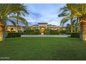 Elegant home featuring a lush green lawn, mature palm trees and manicured hedges at 6852 E Fanfol Dr, Paradise Valley, AZ 85253