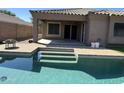 This backyard has a covered patio with a pool that has a three-step entry at 703 E Taylor Trl, San Tan Valley, AZ 85143