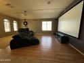 Spacious room featuring a large screen, comfortable seating and hardwood floors at 703 E Taylor Trl, San Tan Valley, AZ 85143
