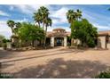 Beautiful front exterior with palm trees, green foliage, a circular driveway, and a grand entrance at 7801 N Saguaro Dr, Paradise Valley, AZ 85253