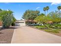 Inviting home showcasing a well-maintained front yard, mature trees, and a long driveway leading to the garage at 8814 N 86Th St, Scottsdale, AZ 85258