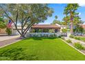 Beautiful home with a well-kept lawn, mature trees, and an American flag displayed near the charming entrance at 8814 N 86Th St, Scottsdale, AZ 85258
