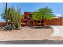 Inviting two-story home with desert landscaping and mature trees, near a concrete driveway at 9137 E Odessa St, Mesa, AZ 85207