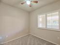 This is a cozy bedroom with a ceiling fan and window with plantation shutters at 920 E Devonshire Ave # 4021, Phoenix, AZ 85014