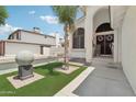 Eye-catching front yard featuring green artificial turf, a palm tree, and a unique spherical sculpture at 11021 N 64Th Ln, Glendale, AZ 85304