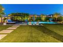 Beautiful backyard with a sparkling pool, lounge area, and lush landscaping, perfect for outdoor entertaining at 11705 W Luxton Ln, Avondale, AZ 85323