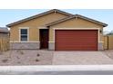 Inviting single-story home with a brick-lined driveway, a red garage door, and desert-friendly landscaping at 35445 N Seedling St, San Tan Valley, AZ 85144