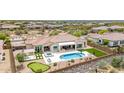 An aerial view showcases the backyard featuring a pool, spa, putting green, and artificial turf at 6032 E Thunder Hawk Rd, Cave Creek, AZ 85331