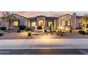 Elegant stucco home featuring desert landscaping, a tile roof, and a welcoming front entrance at sunset at 6032 E Thunder Hawk Rd, Cave Creek, AZ 85331
