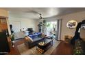 Open living room with a door to a small balcony, a ceiling fan, a couch, and green plants at 740 W Elm St # 264, Phoenix, AZ 85013