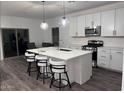Modern kitchen featuring white cabinets, a kitchen island with barstools, and stainless steel appliances at 3023 W Bent Tree Drive Dr # 3023, Phoenix, AZ 85083