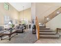 Bright living room with high ceilings, plush sofas, and a staircase, offers a welcoming and spacious atmosphere at 6409 N 11Th Dr, Phoenix, AZ 85013