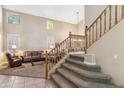 Elegant staircase leading to the upper level, complemented by a view of the comfortable and bright living area at 6409 N 11Th Dr, Phoenix, AZ 85013