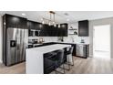 Modern kitchen featuring black cabinets, stainless steel appliances, and a large island with a white countertop at 7149 E Jensen St, Mesa, AZ 85207