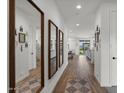 Inviting foyer with wood-look tile flooring, bright natural light, and decorative mirrors at 9740 E Seismic Ave, Mesa, AZ 85212