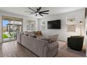 Bright living room with a large sofa, ceiling fan, and sliding glass doors to the backyard at 9740 E Seismic Ave, Mesa, AZ 85212