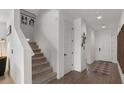 Carpeted staircase featuring a white wall and wood-look tile landing at 9740 E Seismic Ave, Mesa, AZ 85212