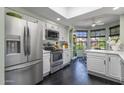 Bright kitchen featuring stainless steel appliances, a skylight, white cabinets, and an adjacent breakfast nook at 10591 E Saddlehorn Dr, Scottsdale, AZ 85258