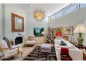 Bright living room with high ceilings, large windows, fireplace, and unique decorative mirror and lighting fixture at 10591 E Saddlehorn Dr, Scottsdale, AZ 85258