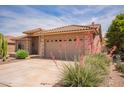 Exterior view of home with desert landscaping and a two-car garage at 10861 E Olla Ave, Mesa, AZ 85212