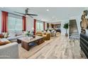 Open-concept living area with modern furnishings, stylish decor, and seamless flow to the dining area and kitchen at 16377 W Weeping Willow Rd, Surprise, AZ 85387