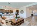 Bright living room featuring a comfortable sofa, stylish decor, and tile flooring at 16842 W Bronco Trl, Surprise, AZ 85387