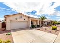 Inviting single-story home with a well-maintained desert landscape and a spacious driveway at 18031 W Udall Dr, Surprise, AZ 85374