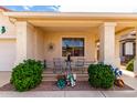 Cozy front porch with decorative plants, outdoor seating, and neutral stucco columns at 18031 W Udall Dr, Surprise, AZ 85374