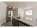 Modern kitchen with stainless steel appliances, gray cabinetry, and a large center island at 2205 S 241St Dr, Buckeye, AZ 85326