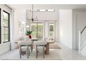 Bright dining area with modern light fixture, large windows, and stylish chairs, creating an inviting space at 2381 W Los Arboles Pl, Chandler, AZ 85224