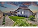 An exterior image of the backyard featuring a covered patio and desert landscaping at 31435 N 130Th Ave, Peoria, AZ 85383