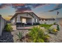 This backyard features a covered patio, desert landscaping, and a synthetic grass area at 31435 N 130Th Ave, Peoria, AZ 85383