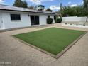 Private backyard with artificial turf, low-maintenance landscaping, and a brick-paved patio, perfect for outdoor gatherings at 3225 E Monica Ave, Phoenix, AZ 85032