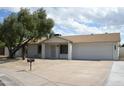 Charming single-story home featuring desert landscaping, mature trees, and a two-car garage in a peaceful neighborhood at 3225 E Monica Ave, Phoenix, AZ 85032