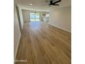 Bright living room with wood flooring, neutral walls, and sliding glass doors leading to the backyard at 3225 E Monica Ave, Phoenix, AZ 85032