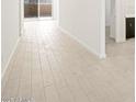 Bright hallway featuring wood-style tile floors and neutral walls, leading to a glass sliding door at 361 S Calle Miguel --, Casa Grande, AZ 85194