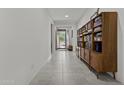 Bright hallway with neutral tile flooring, white walls, and a built-in bookshelf showcasing a modern design at 37103 N El Morro Trl, San Tan Valley, AZ 85140