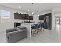 Modern kitchen featuring an island with seating, dark cabinetry, stainless steel appliances, and open layout at 37103 N El Morro Trl, San Tan Valley, AZ 85140
