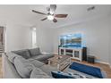 Living room with a large gray sectional, ceiling fan, and a view of the television at 396 S 166Th Dr, Goodyear, AZ 85338