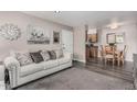 Cozy living room flows into dining area, featuring a gray sofa, and modern flooring at 5877 N Granite Reef Rd # 2240, Scottsdale, AZ 85250
