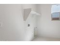 Bright laundry room featuring overhead storage and utility hookups at 662 W Rock Needle Trl, Apache Junction, AZ 85120