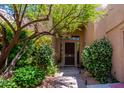 Home's covered front entrance with security door surrounded by lush desert landscaping at 6855 E Amber Sun Dr, Scottsdale, AZ 85266