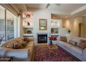 Bright living room featuring a cozy fireplace, built in shelving, and comfortable furnishings at 6855 E Amber Sun Dr, Scottsdale, AZ 85266