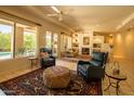Spacious living room with tile floors, fireplace, ceiling fans, and access to the backyard pool area at 6855 E Amber Sun Dr, Scottsdale, AZ 85266