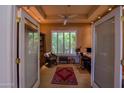 Office featuring custom built-ins, a large window with shutters, and stylish furnishings at 6855 E Amber Sun Dr, Scottsdale, AZ 85266