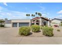 Charming single story home with a stucco exterior, terracotta roof, manicured landscaping, and a three car garage at 9736 E Turquoise Ave, Scottsdale, AZ 85258