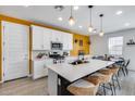 Bright kitchen with white cabinets, an island with barstool seating, and stainless steel appliances at 9916 E Texas Ave, Mesa, AZ 85212
